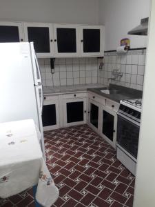 马德普拉塔Villa Lidia的厨房配有白色橱柜和瓷砖地板。