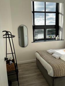 布雷得佛Spire Accommodations Ltd的卧室配有一张床,墙上设有镜子
