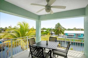 大松礁岛Sunset Villa的阳台配有桌椅,享有水景。