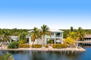 大松礁岛Sunset Villa的棕榈树水边的房子