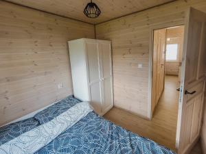 波德古任Szary Domek w Karkonoszach的木制客房内的一间卧室,配有一张床