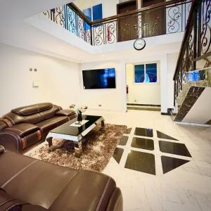 OteleAduk Guest House Airport City Accra的客厅配有沙发和桌子