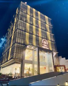 TinsukiaHotel Mirana , Tinsukia的一座大建筑在晚上点燃