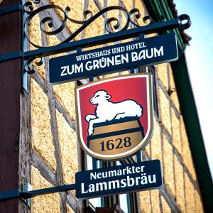 阿尔岑瑙·因·尤特弗兰恩Boutique-Hotel Zum Grünen Baum的建筑物一侧的标志,上面有标志