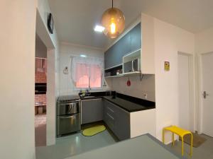 伯迪亚哥Casa em Bertioga condomínio 250 metros da praia的厨房配有蓝色橱柜和黄色凳子