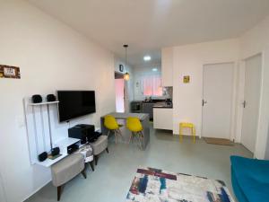伯迪亚哥Casa em Bertioga condomínio 250 metros da praia的客厅配有桌子和黄色椅子