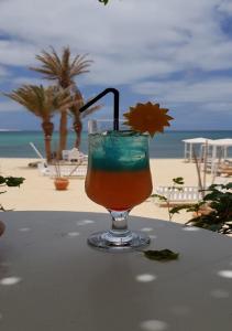CabeçadasSea view houses, Praia de Chaves, Boa Vista, Cape Verde, FREE WI-FI的坐在海滩旁的桌子上喝一杯