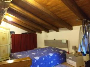 Roccasparverala casa di nonna pina的一间卧室设有蓝色的床和木制天花板