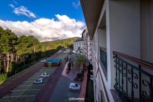 佩德拉阿祖尔Vista Azul Hotel的停车场内停车的建筑物的阳台