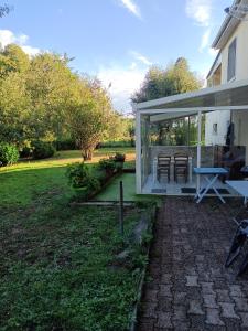 Entre Puy-de-Dôme et Corrèze Appartement pour 4 personnes avec terrasse et jardin的一座带庭院的玻璃房子的延伸部分