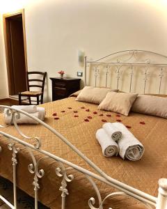 巴勒莫LE PORTE DI PALERMO的一间卧室配有一张带毛巾和玫瑰的床