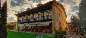 Toñanes拍拉兹恩德拖南尼斯酒店的带阳台和绿色庭院的建筑