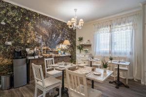菲乌米奇诺鲁丽沃费密西诺住宿加早餐旅馆的用餐室配有桌椅和壁画