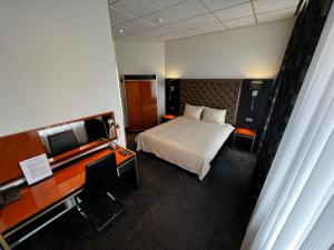 米德尔堡美丽河滨酒店的配有一张床和一张书桌的酒店客房
