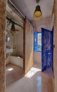舍夫沙万Casa Amina的浴室设有蓝色门和浴缸。