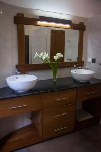 基加利The Little Hill Boutique Hotel的浴室设有2个水槽、镜子和鲜花