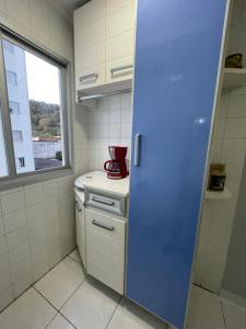 大普拉亚Ap aconchegante 12 min a pé p Praia的柜台上配有红色用具的厨房