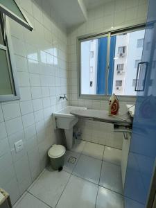 大普拉亚Ap aconchegante 12 min a pé p Praia的一间带水槽和卫生间的浴室以及窗户。