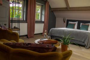 布鲁克赫伊曾Landhuis Hotel de Hilkensberg的一间卧室配有一张床、一张沙发和一张桌子