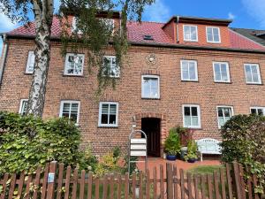 新勃兰登堡große Wohnung zentral gelegen的前面有栅栏的砖房