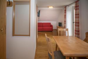 亚亨瑙Hotel im Sonnental的客厅配有桌子和红色沙发