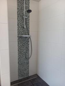 Stuifzand斯塔尔扎特沙普公寓酒店的浴室铺有白色瓷砖,设有淋浴。