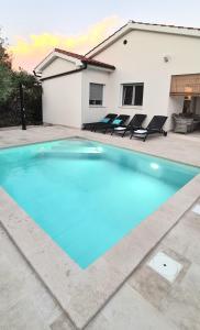 奥米沙利Villa Nevera的一座大蓝色游泳池,位于房子前