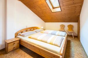 纳图尔诺Unterversanthof - Große Ferienwohnung für bis zu 6 Personen的一间卧室设有木床和天窗