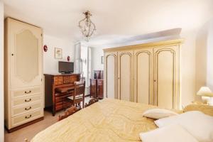 圣雷莫Dimora Bellavista,garage privato,due piani的一间卧室配有一张床、梳妆台和书桌