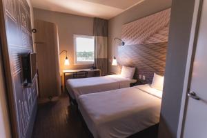 洛雷纳Ibis Lorena - Circuito da Fé的酒店客房设有两张床和电视。