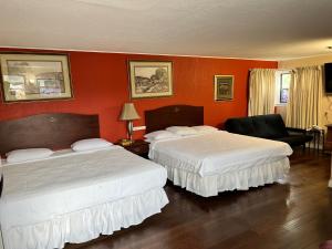 塞奎姆格瑞特豪斯汽车旅馆的橙色墙壁的酒店客房内的两张床
