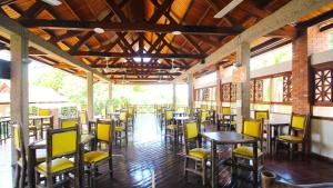 吉拉尔多特On Vacation Girardot Resort的用餐室配有桌子和黄色椅子