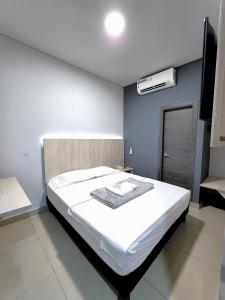 图马科HOTEL NABU DEL PACIFICO的卧室配有白色的床和蓝色的墙壁