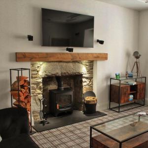 基林Laburnam Villa - Luxury 4 bedroom accommodation in the heart of Killin的客厅设有壁炉,上面配有电视