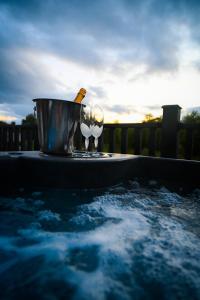 因弗戈登Newmore Highland Pods with Hot Tubs on NC500的热水浴池,配有桶和葡萄酒杯