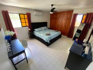 圣地亚哥洛斯卡巴Casa Corona Plaza的一间卧室设有床和两张桌子及窗户。