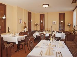 埃尔姆山麓克尼格斯卢特尔克恩纳斯登酒店的一间设有白色桌椅的用餐室