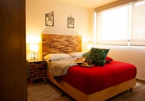 墨西哥城Kolben Nuoma的一间卧室配有一张红色床罩的床