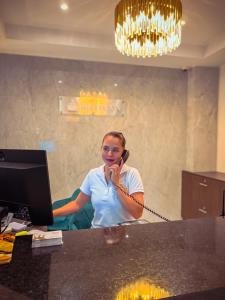 卡利Hotel Qatar Cali的办公室里的一个女人在说手机