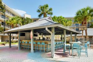奥兰多Staybridge Suites Orlando Royale Parc Suites, an IHG Hotel的一个带桌椅的凉亭和一间酒吧