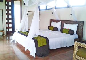 乌鲁瓦图杜克滨金别墅酒店的一间卧室配有两张带白色床单的床
