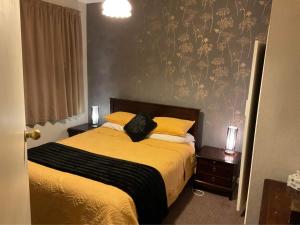 因弗卡吉尔Bungalow on Centre的一间卧室配有一张带黄色床单和黄色枕头的床。