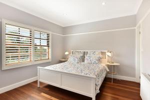 卢拉Alleura House的白色的卧室设有床和窗户