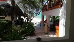 江比阿Red Monkey Beach Lodge的站在阳台上的穿着白色衣服的女人