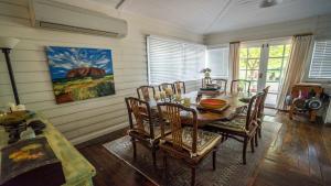 卢拉Rose Pine Cottage at Leura的一间带木桌和椅子的用餐室