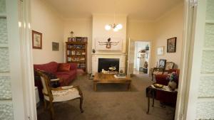 卢拉Rose Pine Cottage at Leura的客厅设有红色的沙发和壁炉