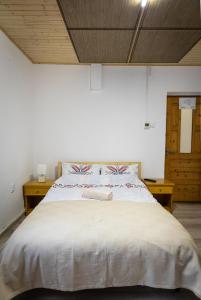 杜劳Pensiunea Novac的卧室配有一张白色大床和木制天花板