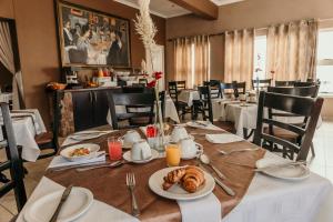 斯瓦科普蒙德Artemis Hotel Swakopmund的用餐室配有餐桌和食物