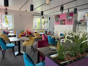 库克斯港Hotel Gasthof Zur Post的餐厅设有多彩的桌椅和桌面