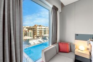 迪拜Studio M Arabian Plaza Hotel & Hotel Apartments的客房设有一个享有泳池景致的窗户。